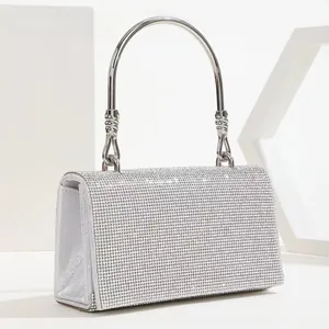 Detailed close-up of a silver rhinestone evening bag with elegant metal handle