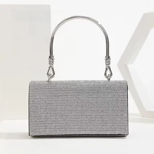 Macro shot of silver evening clutch bag with sparkling rhinestones and metal ring handle