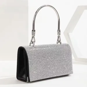 Macro shot of silver rhinestone evening bag with side fabric detail and metal handle