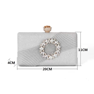 Pochette de soirée argentée pailletée avec ornement en strass et fermoir rose