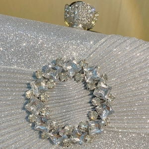 Détail de la pochette de soirée à paillettes argentées avec strass brillants et fermoir cristal
