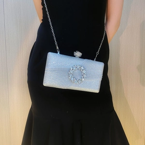Gros plan d'une pochette de soirée en paillettes argentées avec boucle en strass et chaîne
