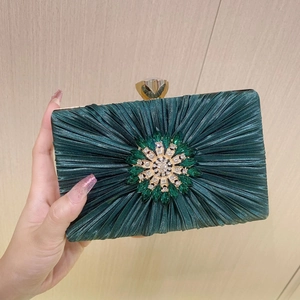 Pleated emerald green satin evening clutch bag with sparkling sunburst rhinestone ornament