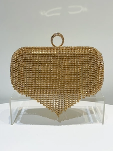 Detail van luxe gouden avondtas met strass-steentjes en een elegante ringvormige sluiting