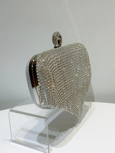 Detail van luxe zilveren avondclutch met fonkelende strassteentjes en lange kwastjesversiering