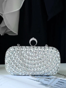 Close-up of sparkling silver rhinestone clutch featuring a ring clasp and metallic chain