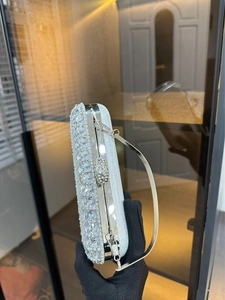 Side view of silver rhinestone evening bag with sparkling gems and metal chain handle