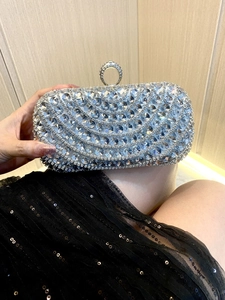 Detailed view of silver evening clutch bag with sparkling crystals and ring clasp handle