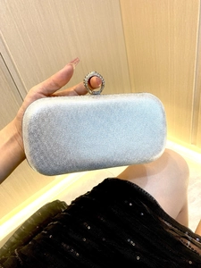 Close-up of silver glitter evening clutch bag with sparkling diamond ring-top clasp