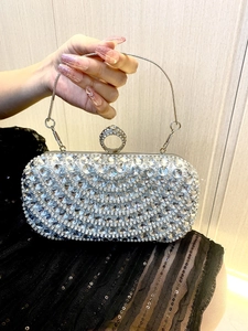 Close-up of sparkling silver rhinestone evening bag with elegant crystal ring clasp