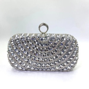 Detail of silver evening clutch bag featuring sparkling rhinestones and a ring-shaped clasp