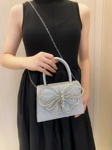 Silver rhinestone evening bag featuring a large 3D butterfly buckle and metal chain