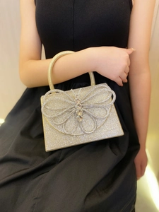 Detailed view of the luxury gold rhinestone evening bag with a large crystal butterfly