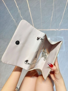 Detailed view of the champagne glitter evening bag interior with silver chain and magnetic snap