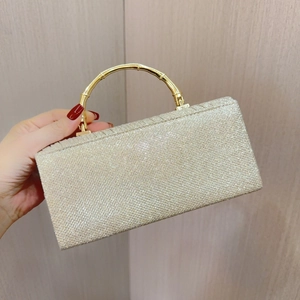 Detail der goldenen Abendtasche mit Glitzer und einzigartigem Bambusgriff aus Metall