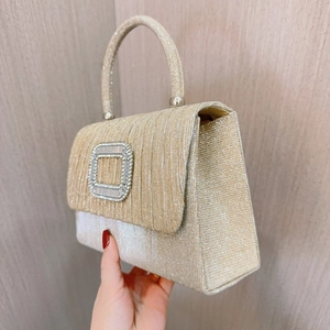 Detailansicht der champagnerfarbenen Abendtasche mit Falten, Strassschnalle und Tragegriff