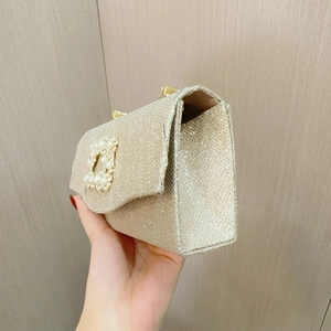 Makroansicht der goldenen Abendtasche mit Perlenschnalle und feiner Glitzertextur