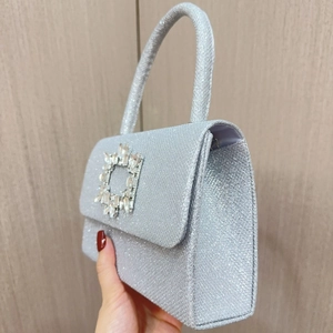 Detail of silver sequin evening bag featuring a crystal square buckle and top handle