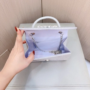 Detail view of silver glitter evening bag with rhinestone clasp and metal chain strap