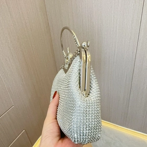 Vue détaillée du sac de soirée argenté orné de strass brillants avec une poignée anneau en métal