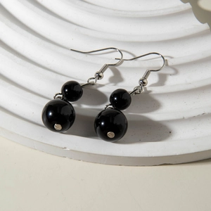 Gothic style black beaded acrylic earrings with silver hooks on minimalist white background