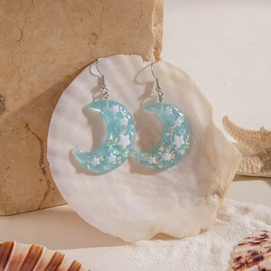 Light blue resin crescent moon earrings with laser glitter and stars on sea shells