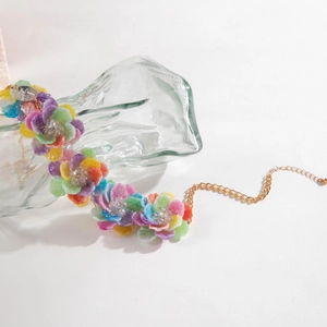 Detail der bunten Kunstharz-Blumenkette mit Goldkette auf Glas-Display-Ständer