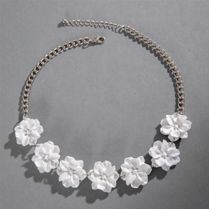 Détail des fleurs 3D blanches mates sur collier argenté avec fermoir mousqueton robuste