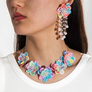 Details der bunten matten Blumenkette und Ohrringe mit Perlenquasten an einem Model
