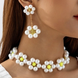 Detailaufnahme von handgefertigtem weißen Perlen-Choker und passenden Ohrhängern
