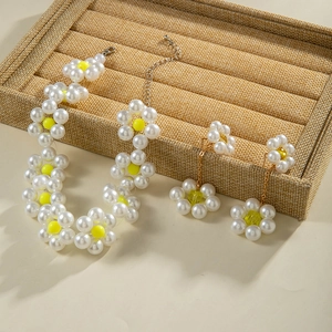 Detail von floralem Perlenhalsketten-Set mit weißen Perlen und gelben Akzenten auf Halter