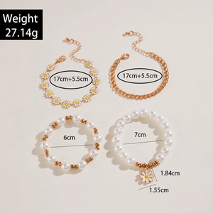 Set of 4 gold-tone daisy bracelets with faux pearls and geometric chains on beige background