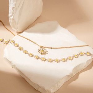 Chic multi-layered necklace set featuring white daisy pendants and golden chain links