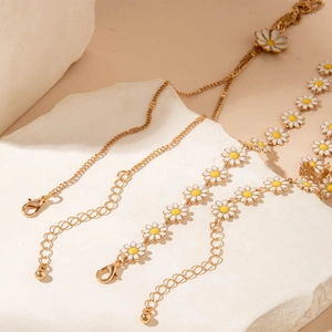 Chic gold necklace and bracelet set featuring white enamel daisy flowers on fine chains