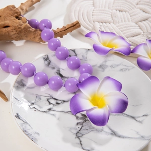 Parure collier perles acryliques violettes et boucles d'oreilles fleur de frangipanier