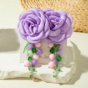 Detail of purple silk rose earrings with beaded fringe tassels and green leaf charms