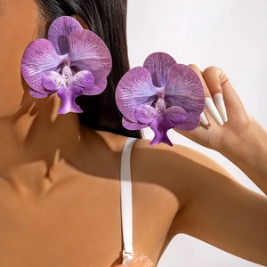 Close-up of elegant purple orchid earrings with gradient petals on a model