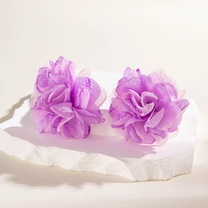 Detailed close-up of handmade purple floral fabric hair accessories on stone display