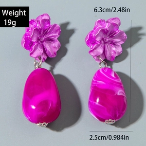 Detailed view of handmade beaded earrings with rose flower and turquoise drop pendant