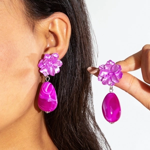 Detail shot of pink flower earrings with oval turquoise marble drop pendants worn by model