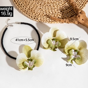 Détail macro du collier et des boucles d'oreilles orchidée avec pétales dégradés et perles
