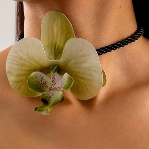 Gros plan d'un tour de cou orchidée avec pétales jaunes réalistes et cordon tressé noir