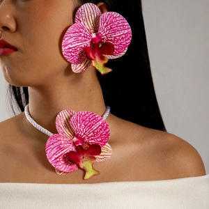 Détail de la parure orchidée avec pétales rayés roses et accents de perles