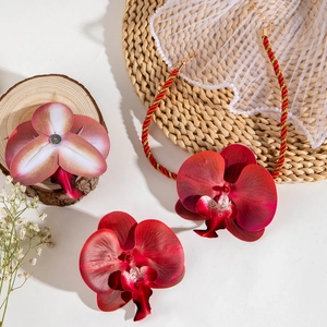 Détail d'une parure d'orchidées rouges avec cordon tressé sur un fond de style rustique