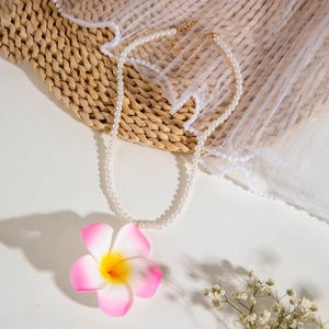 Détail du collier de perles bohème avec fleur d'orchidée rose et fermoir doré ajustable