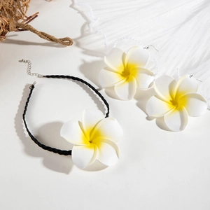 Vue macro détaillée du collier et des boucles d'oreilles en forme de fleur de frangipanier