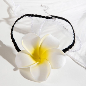 Détail du collier fleur de frangipanier avec cordon noir et décor de perles
