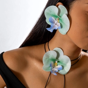 Gros plan d'une parure d'orchidées vert clair réaliste avec pétales en tissu sur un modèle