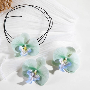 Gros plan d'un ensemble de bijoux floraux avec collier orchidée et pinces à cheveux assorties