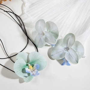 Détail du parure de bijoux orchidée avec pétales sarcelle et accents de perles